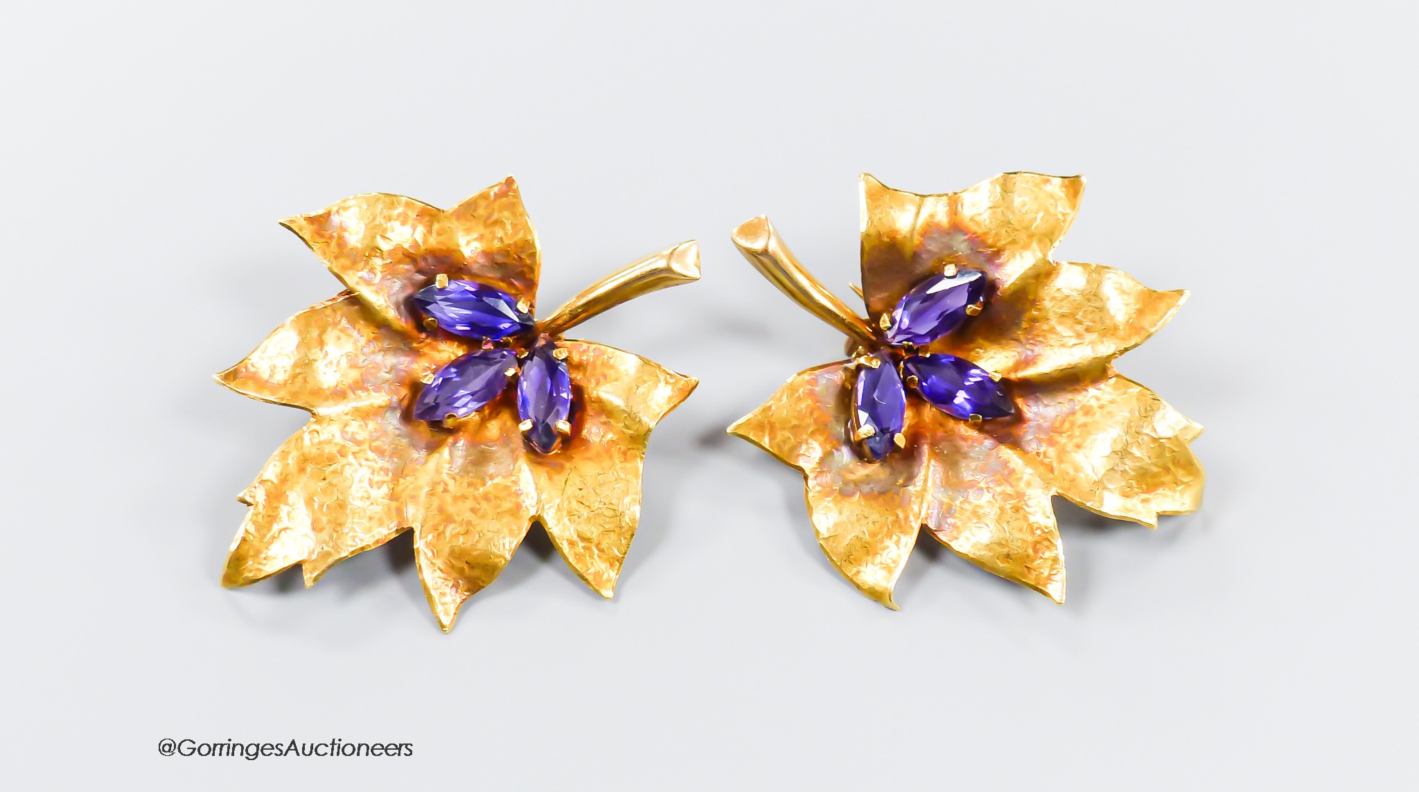 A pair of 750 yellow metal and three stone amethyst set leaf brooches, 38mm, gross 11.2 grams.
